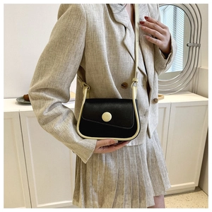 Detail of minimalist saddle bag with black and white contrast worn by a model