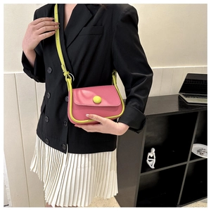 Detail view of pink and neon green contrast saddle bag with adjustable shoulder strap