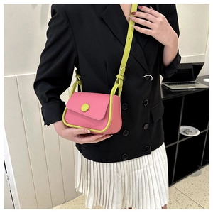 Detail of pink and neon green crossbody bag with contrast stitching and round buckle