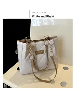 Close-up of quilted white leather tote bag with khaki trim and gold chain detail