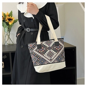 Détail du sac cabas ethnique à motif géométrique porté à l'épaule par un mannequin