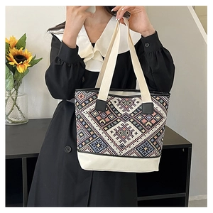 Photo lifestyle d'un sac cabas ethnique avec motifs géométriques colorés et garniture blanche
