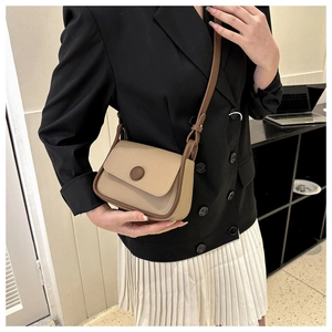 Model wearing a retro color-block saddle bag with beige leather and brown trim details