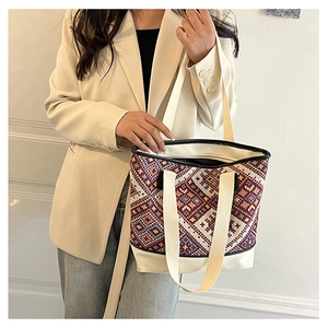 Détail du tissage géométrique aux motifs ethniques sur un sac seau en toile avec finitions