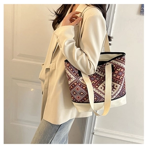 Détail du sac seau en toile tissée géométrique ethnique sur l'épaule d'un mannequin