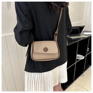 Detailed back view of a retro saddle bag in beige and brown shown on a model