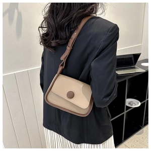 Rear view of a model wearing the beige and brown vintage saddle bag for sizing reference