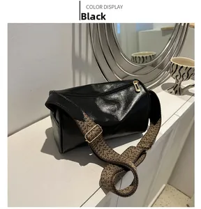 Dettaglio borsa a cilindro nera con tracolla larga in tessuto a motivi geometrici