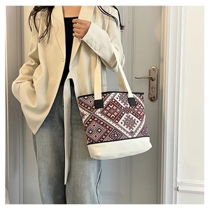 Détail des motifs ethniques tissés sur un sac seau en toile avec bandoulière contrastée