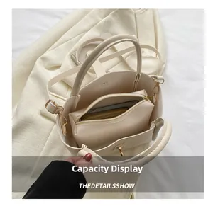 Capaciteitsweergave van de beige kunstlederen bucket bag met binnentas en goudkleur