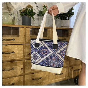 Détail du sac seau rétro montrant le tissage ethnique et les coutures en toile ivoire