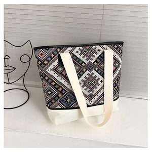 Détail du sac cabas tissé ethnique avec poignées en toile blanche sur fond minimaliste moderne