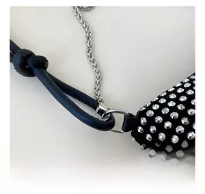 Macro view of black leather bag with silver studs and durable metal chain link