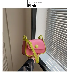 Close-up of pink and neon green saddle bag with contrast piping and smooth leather texture