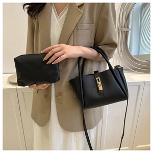 Detail van zwarte crossbody emmertassen set met gouden hardware bij een model