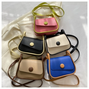 Flat lay of retro contrast color saddle bags with decorative round buckles in five colors