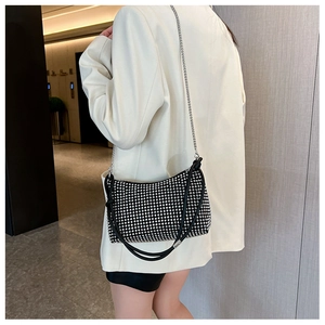 Detail of a sparkling rhinestone hobo bag featuring mixed chain and leather straps
