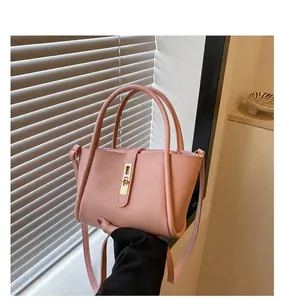 Detail van roze emmertas met een gouden metalen gesp en een strakke matte afwerking