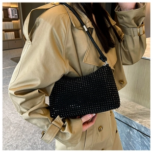 Detail of elegant black rhinestone shoulder bag with delicate sparkles on leather strap