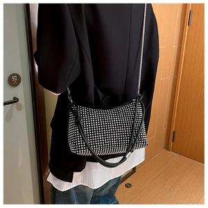 Detail of black rhinestone shoulder bag with silver chain strap on model's shoulder