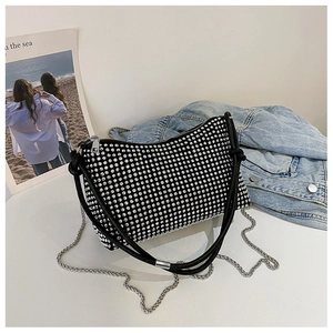 Detail of black rhinestone shoulder bag with silver chain and shimmering crystal texture