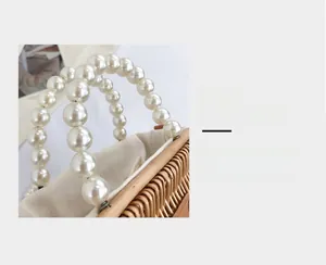 Detailed macro view of woven straw bag featuring elegant faux pearl handle and inner lining