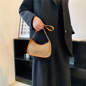 Brown half-moon underarm bag with silver rivets and leather strap on fashion model