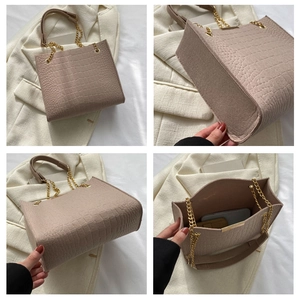 Detailed view of crocodile pattern tote bag with gold chain strap and interior space