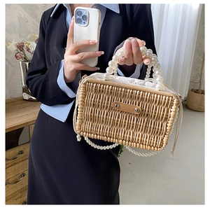 Detail of hand-woven rattan bag with pearl handles and drawstring canvas lining