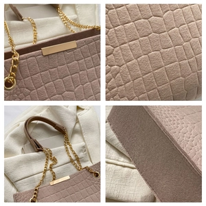 Detail view showing crocodile embossed felt texture and gold hardware on tote bag