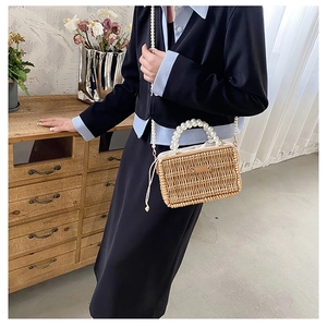 Detail of handmade wicker box bag featuring pearl handles and drawstring closure