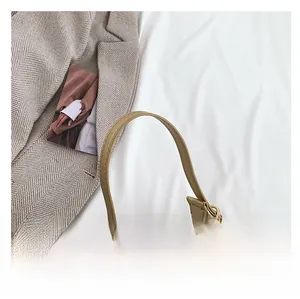 Close-up of golden crescent bag with crocodile texture and metal zipper detail