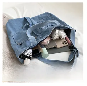 Detail view of large blue denim tote bag interior showing multiple storage pockets
