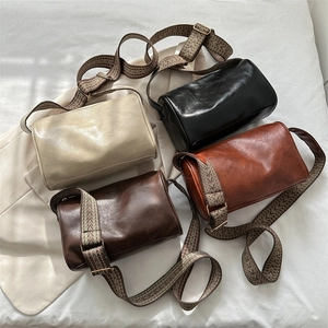 Minimalist wide strap cylinder crossbody bag in multiple colors with patterned strap