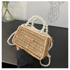 Detail of hand-woven straw bag featuring pearl handle and drawstring lining detail