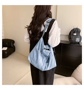 Detail of adjustable strap and outer pocket on washed denim tote bag for women