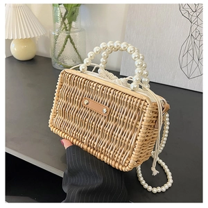 Detailed macro view of retro woven rattan bag featuring elegant white pearl handles