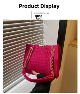 Macro detail of rose red tote bag featuring crocodile texture and gold chain strap