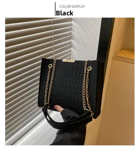 Close-up of black felt tote bag featuring embossed crocodile pattern and gold chain strap