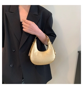 Detail of golden crescent handbag showing exquisite crocodile embossed texture on faux leather