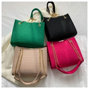 Flat lay of crocodile pattern felt tote bags in green, black, beige, and rose pink colors