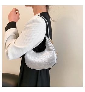 Close-up of silver crocodile pattern texture on hobo crescent shoulder bag with gold buckle