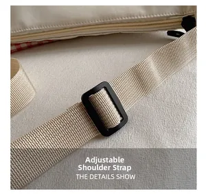 Détail de la bandoulière en nylon réglable et boucle d'un sac à carreaux beige