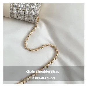 Détail de la texture en tweed du sac bandoulière avec chaîne dorée entrelacée de cuir