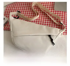 Détail du sac bandoulière en nylon crème avec sangle réglable et fermeture éclair cachée