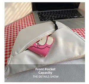 Détail montrant la capacité de la poche avant du sac en nylon avec un petit portefeuille