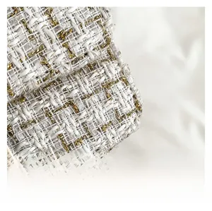 Vue macro de la texture du tissu en tweed blanc et doré avec fils métalliques tissés
