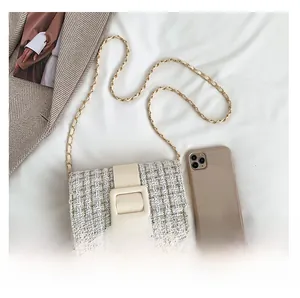 Détail de la texture en tweed, boucle en cuir et chaîne dorée sur le petit sac carré