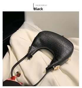 Close-up of black crocodile pattern leather underarm bag with gold metal zipper and details