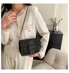 Détail du sac bandoulière en tweed noir avec texture fil d'or et bandoulière chaîne